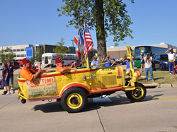 Yellow three-wheeled car with American flag and Shriners decals